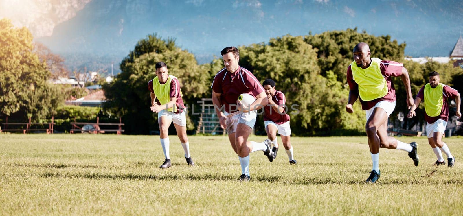 Game, sports and men playing rugby in a competition, match and running with a ball on a field. Fitness, exercise and players training for a team sport, cardio and collaboration in a park for practice by YuriArcurs