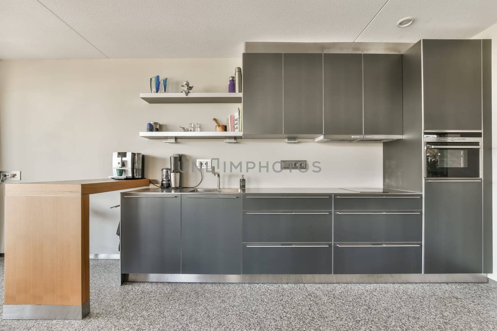 a kitchen with stainless steel cabinets and a wooden counter by casamedia