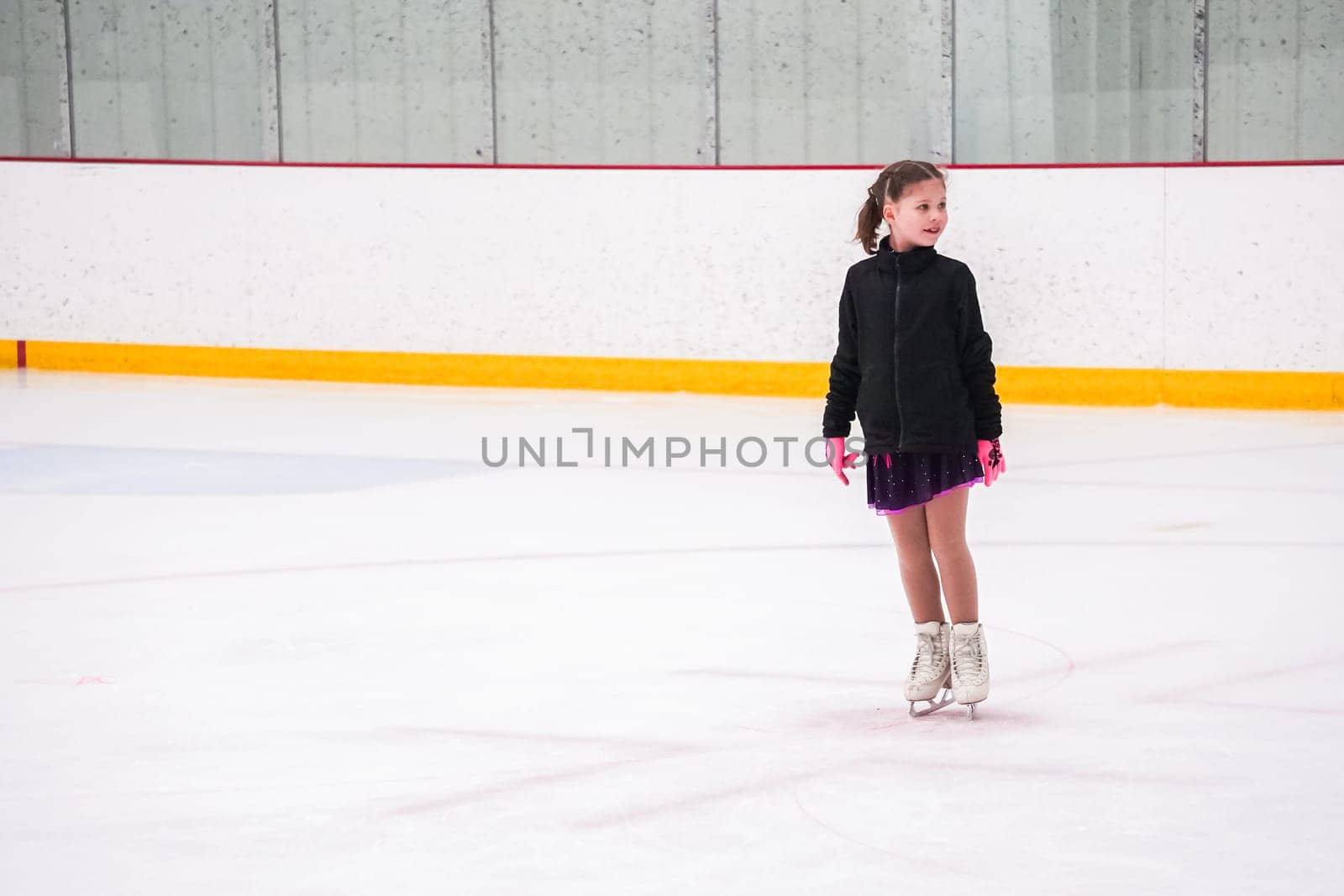 Little girl practicing before her figure skating competition at the indoor ice rink.