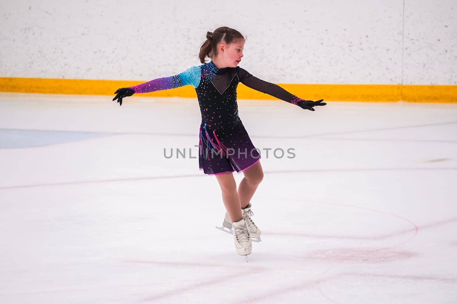 Little girl practicing before her figure skating competition at the indoor ice rink.