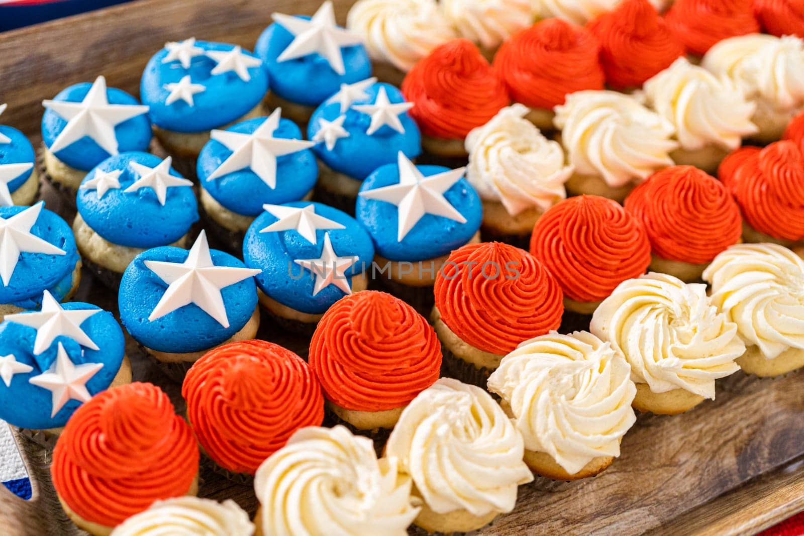 Arranging mini vanilla cupcakes in the shape of the American flag.