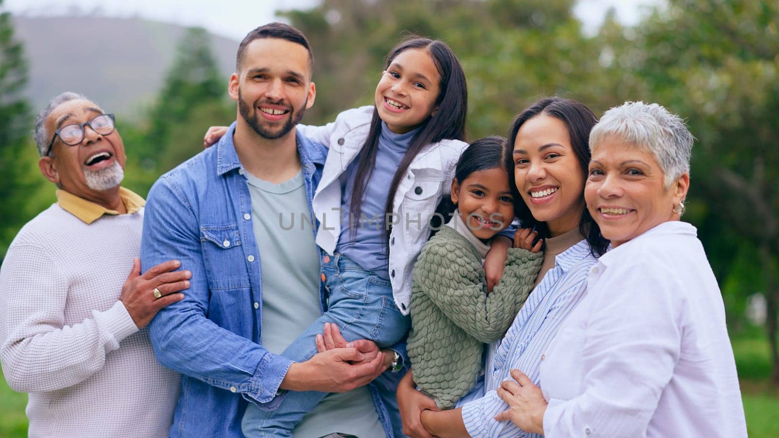 Park portrait of grandparents, happy kids and parents, smile and bonding adventure in nature. Hug, fun or memory for big family on picnic, men and women with children in garden with love, mom and dad.