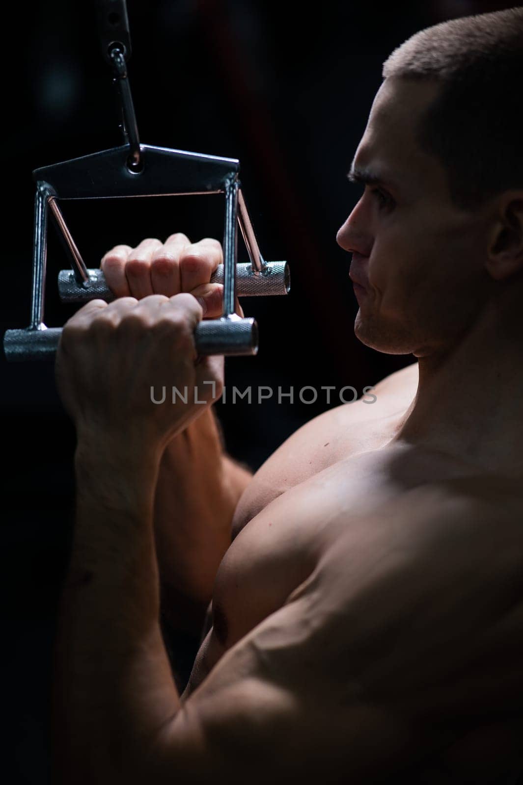 A man does a chest pulldown in the gym