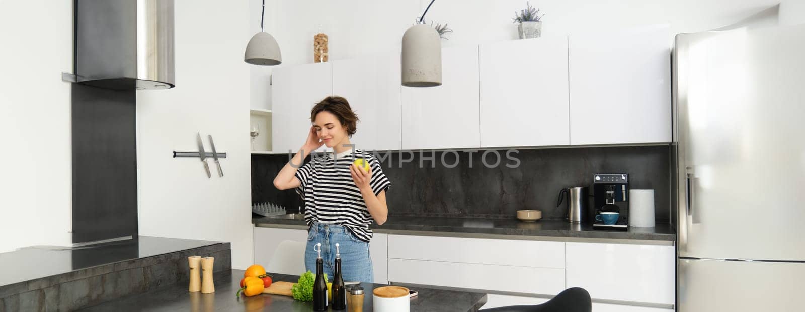 Portrait of young woman cooking salad. Cute girl vegan chopping vegetables on kitchen counter, preparing food.