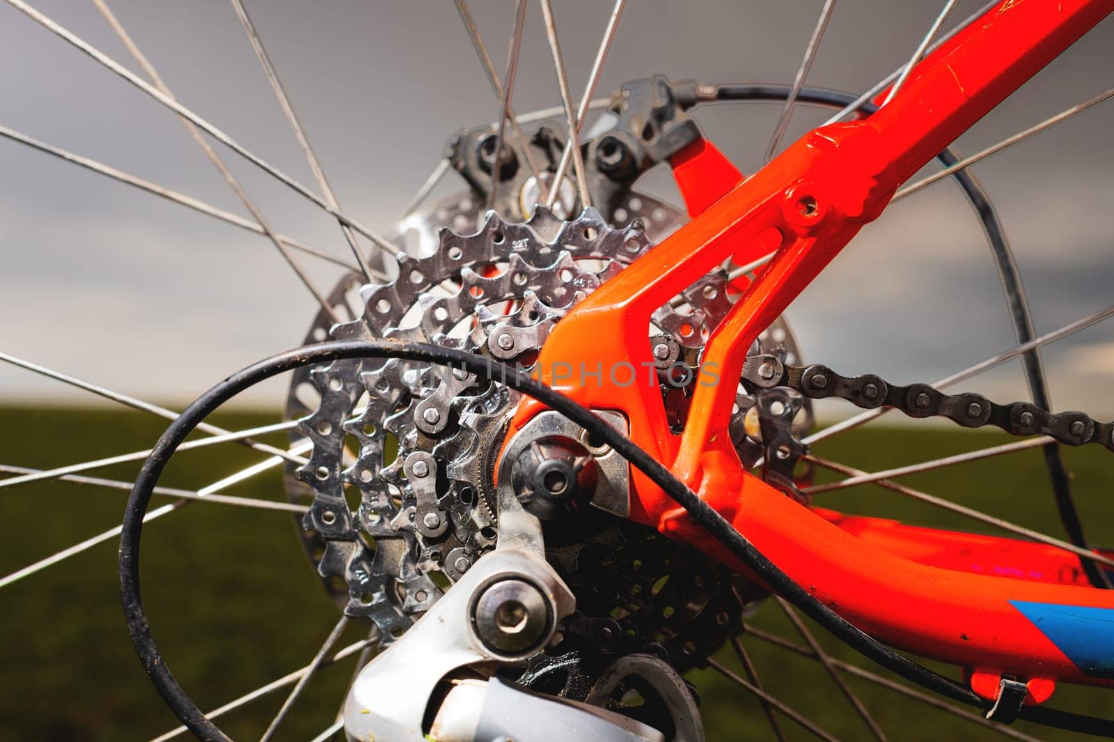Close-up of mountain bike sprockets and chain. Bicycle parts, fragment of rear wheel brake disc, frame.