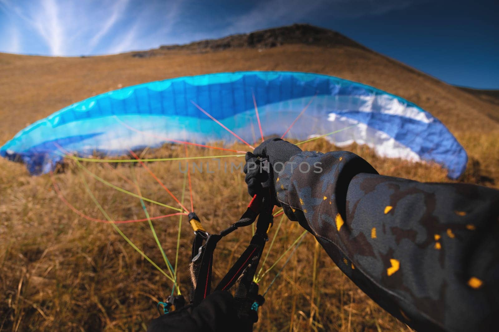 Point of view of a skydiver piloting his parachute. Hands holding the lines of their parachute, wide angle view by yanik88