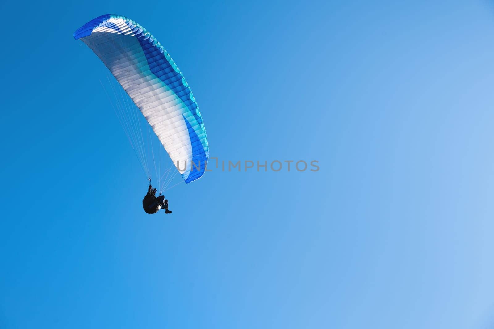 paraglider flies in the blue clear sky. Paragliding in the sky on a sunny day by yanik88
