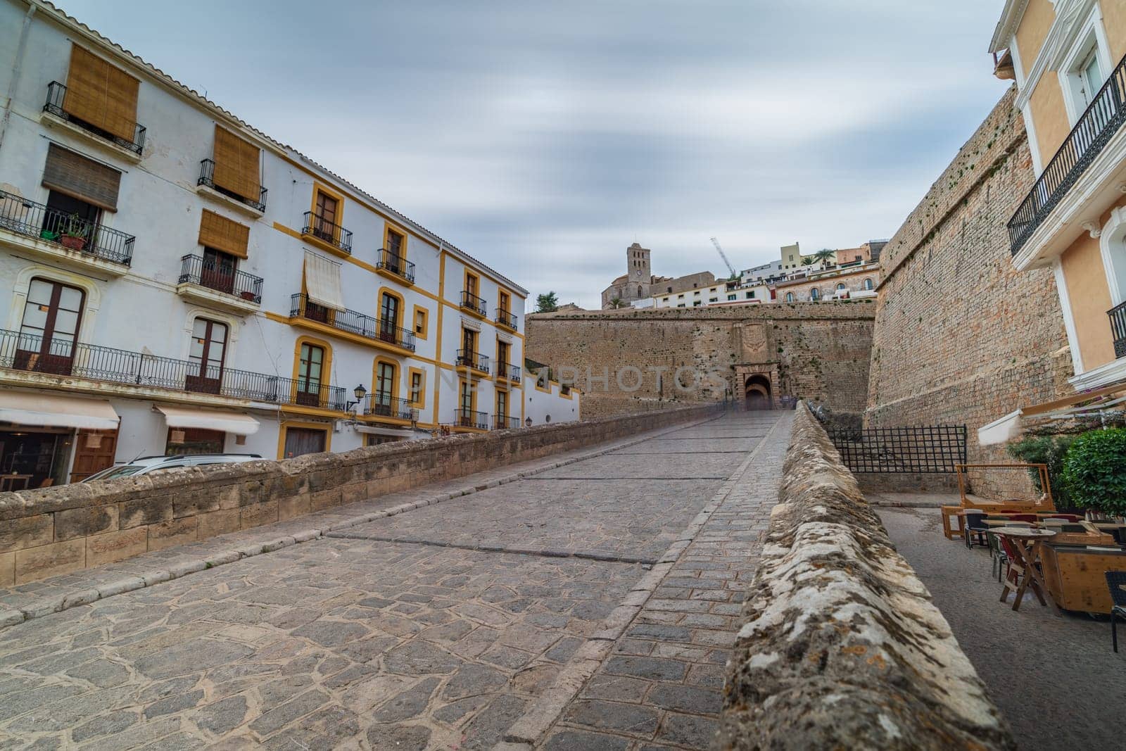 Long exposure photo of Ibiza's old city entrance with protective walls and gate, devoid of people, exuding serenity