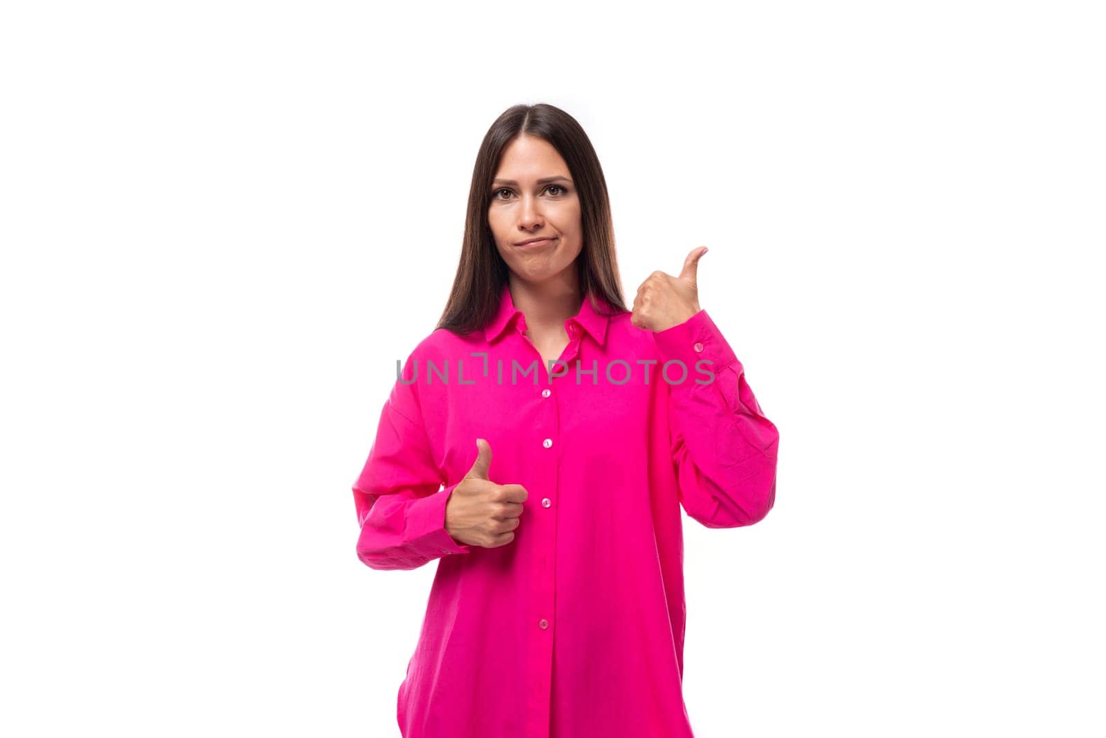 a cute young brunette european woman in a crimson shirt uses gestures to carry on a conversation.