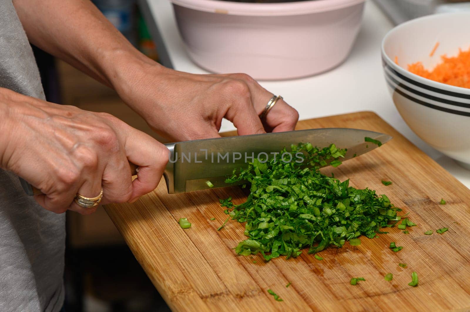 woman cutting parsley on a cutting board in the kitchen 1