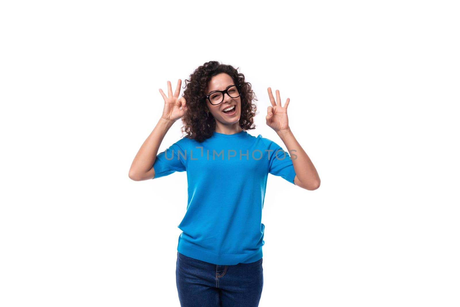 confident successful young caucasian woman with curls dressed in a blue t-shirt.