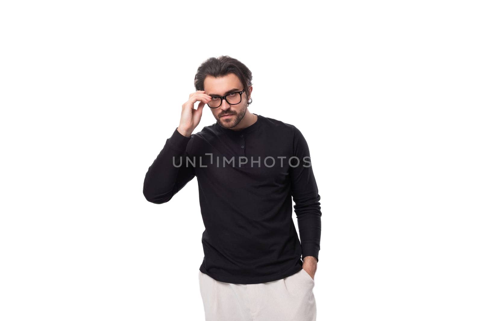 young pensive european guy with stubble and mustache in a black turtleneck and glasses.