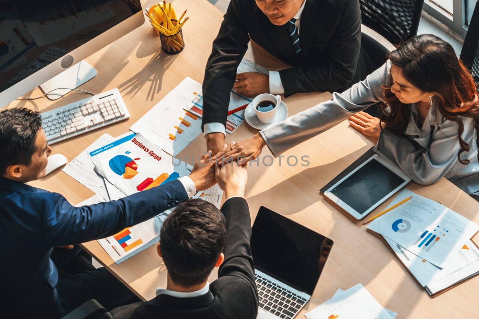 Happy business people celebrate teamwork success together with joy at office table shot from top view . Young businessman and businesswoman workers express cheerful victory show unity support . Jivy