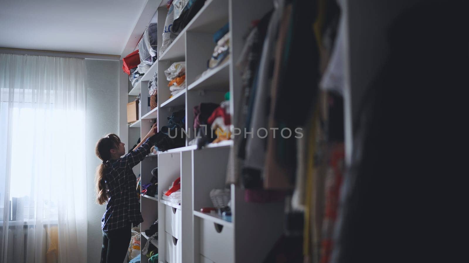 The mother is a housewife looking for clothes in the closet