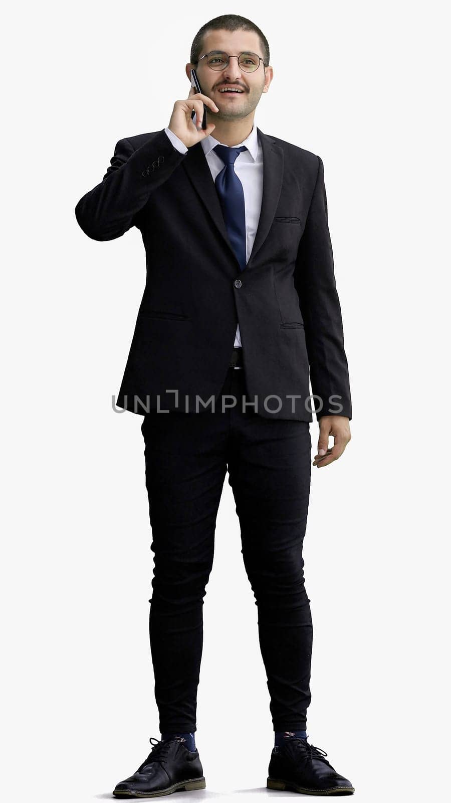 young man in full growth. isolated on white background speaks on the phone.