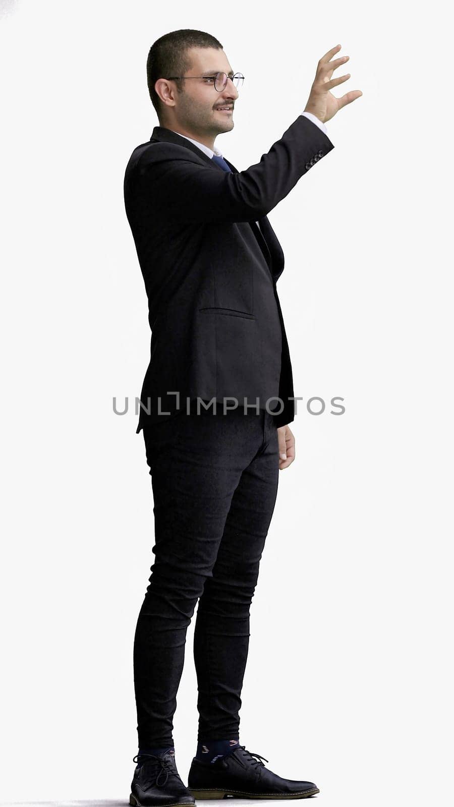 young man in full growth. isolated on white background pointing with finger.