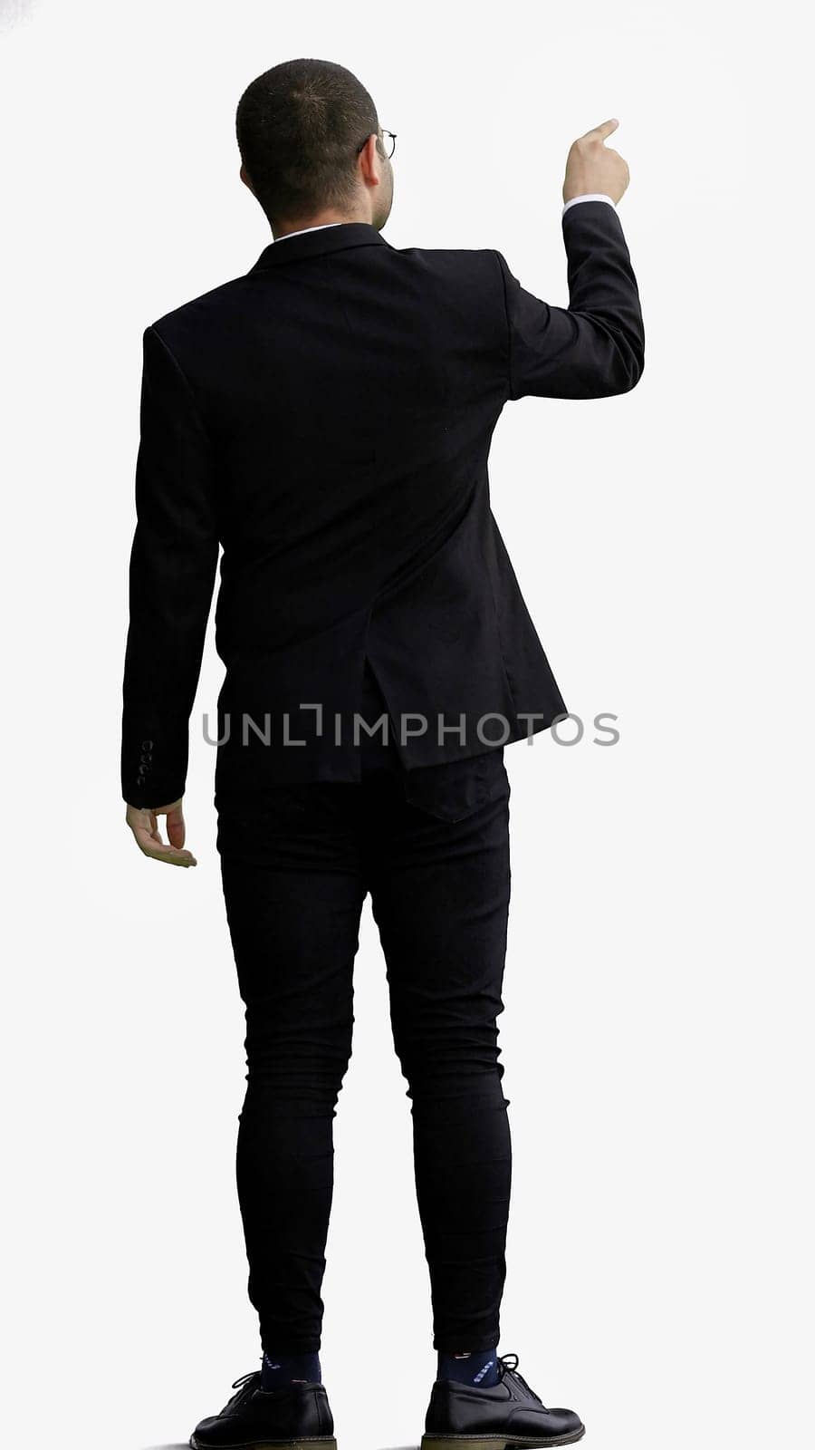 young man in full growth. isolated on white background pointing with finger.