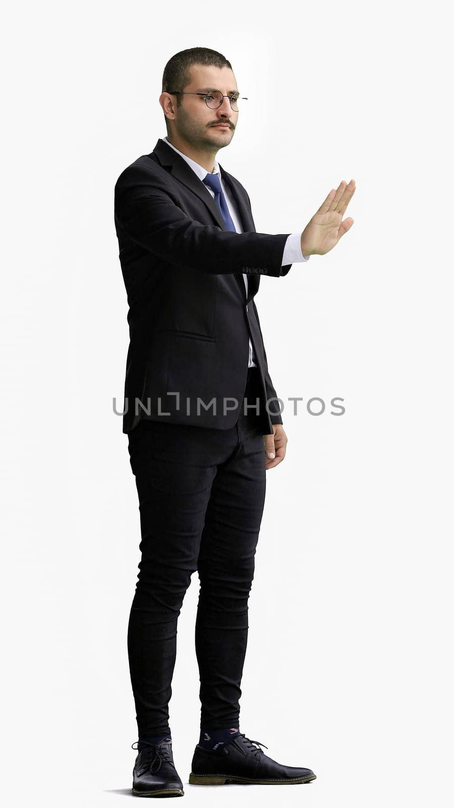 man in full growth. isolated on white background shows stop sign with hand.