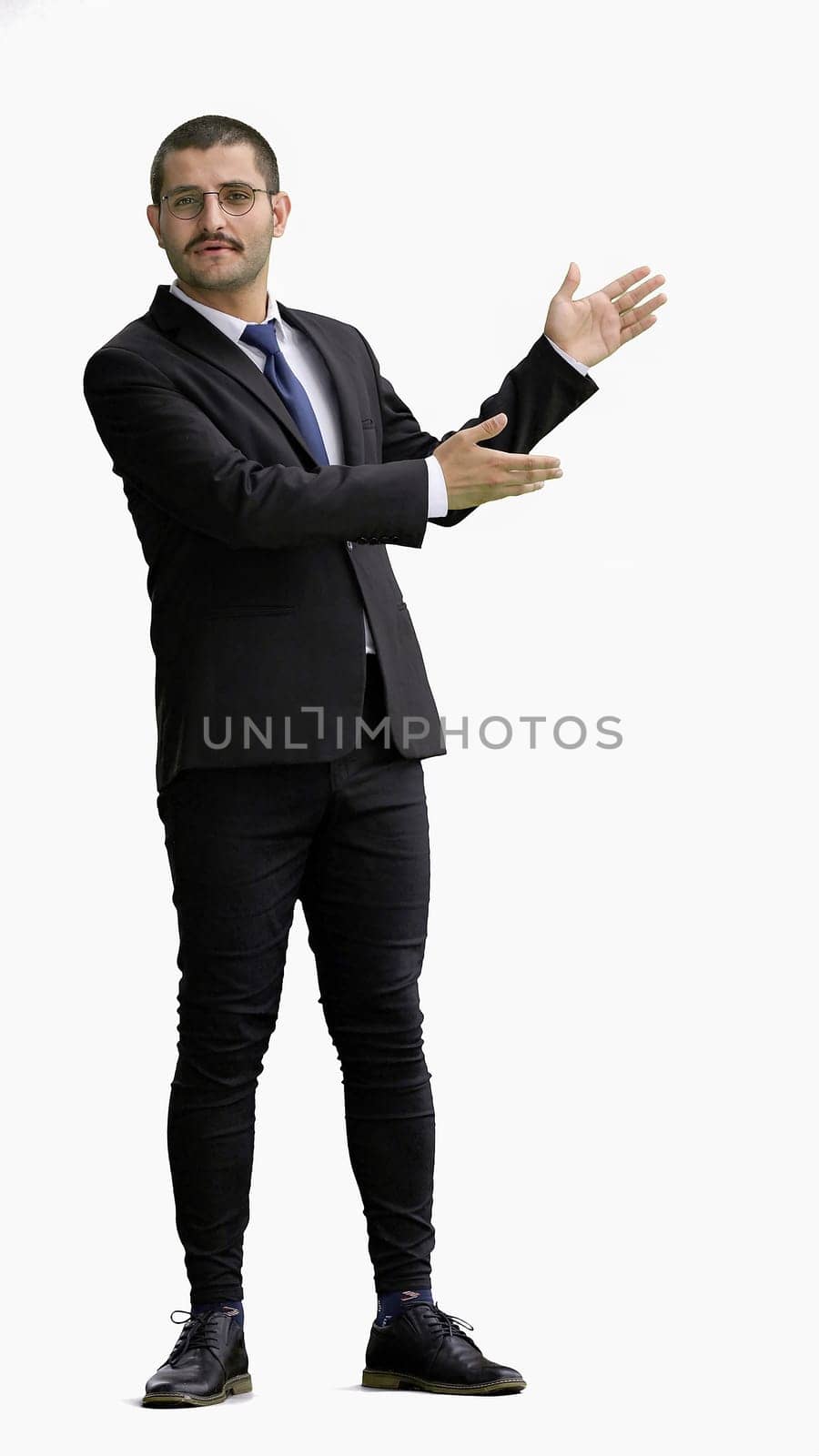 young man in full growth. isolated on a white background shows hands to the side.