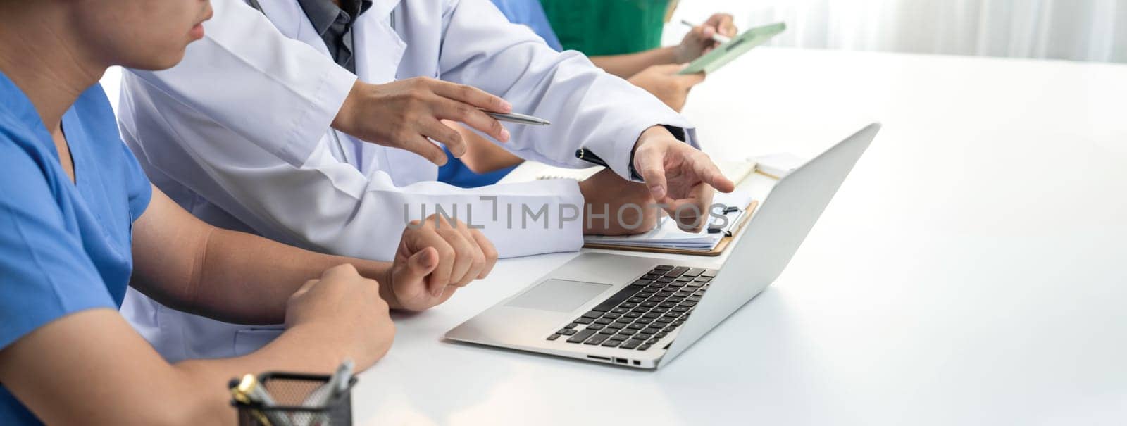 Professional various team of medical working and planning medical treatment at hospital table together. Teamwork lead to successful illness and sickness treatment. Panorama Rigid