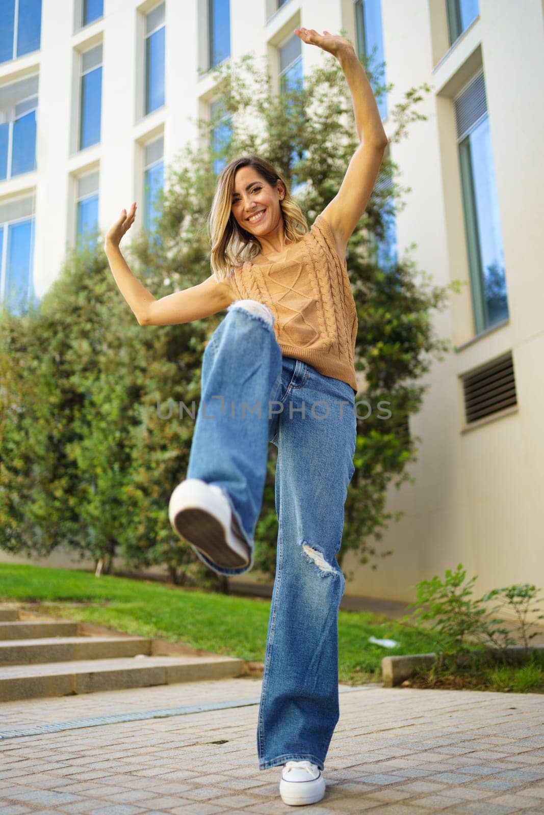 Stylish woman dancing on street by javiindy