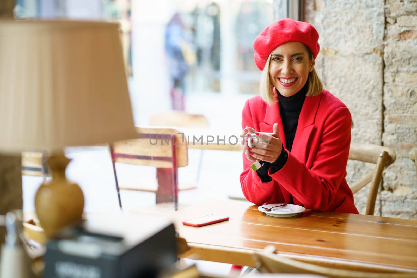 Cheerful woman with coffee in cafe by javiindy