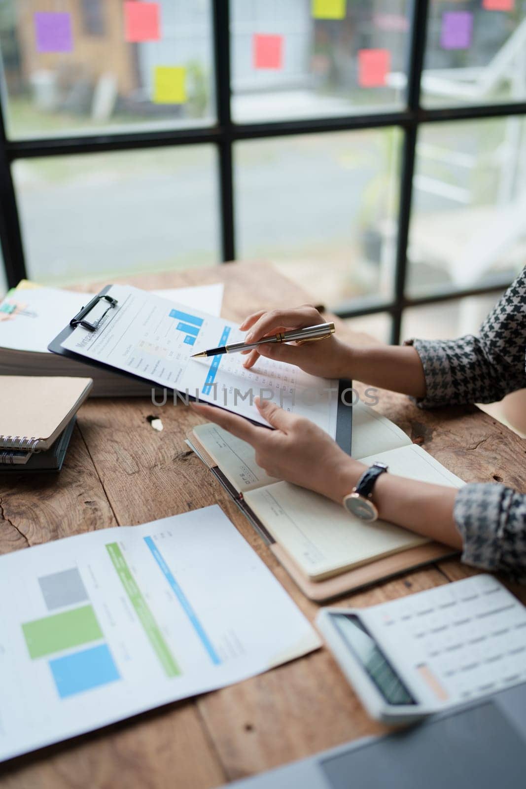 female employee holds a pen and checks investment financial documents