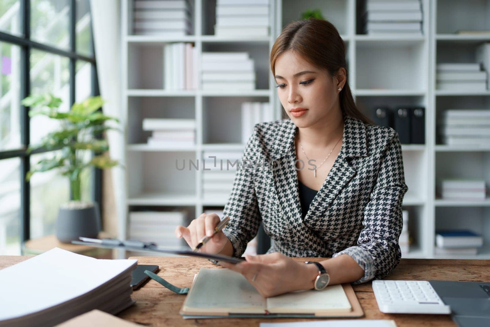 female employee holds a pen and checks investment financial documents