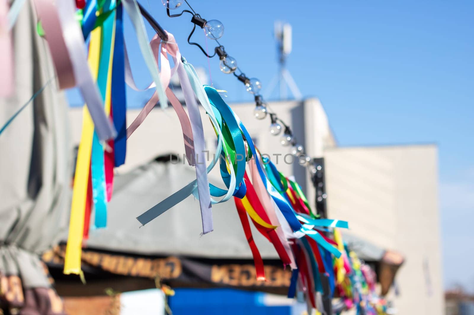 Colorful ribbons on a rope on the background of the blue sky