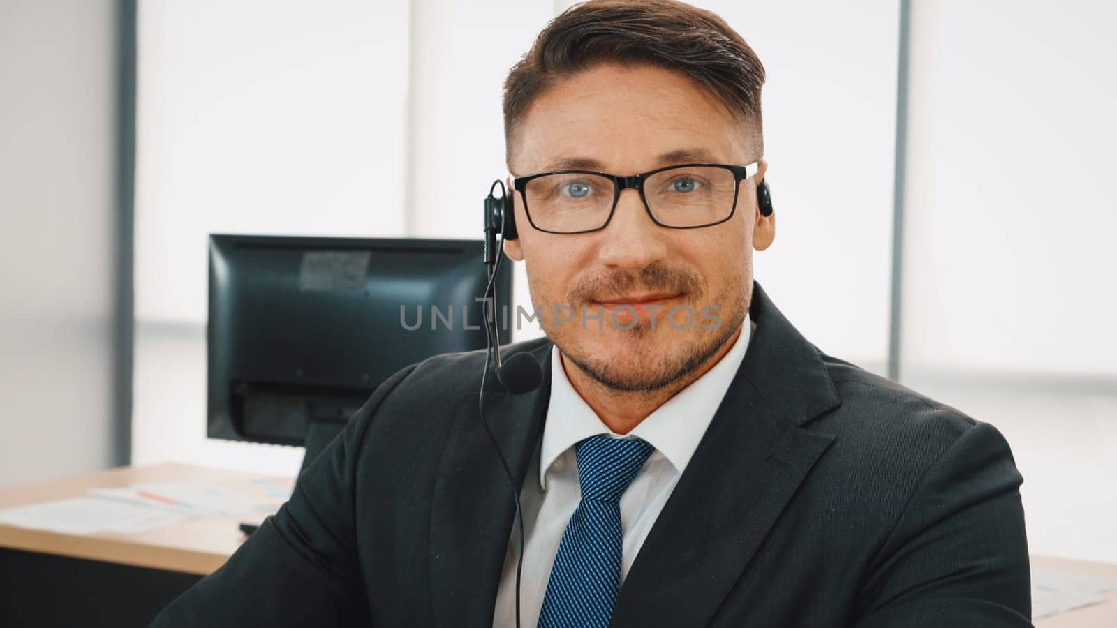 Business people wearing headset working in office to support remote customer or colleague. Call center, telemarketing, customer support agent provide service on telephone video conference call. Jivy