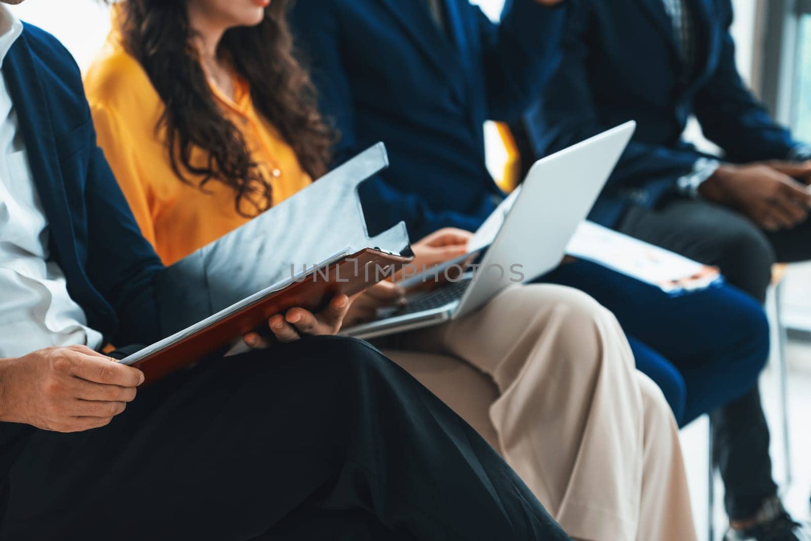 Diversity candidates waiting for job interview. Intellectual. Low section crop of interviewees sitting on a chair while preparing their document and themselves for presentation. Intellectual.