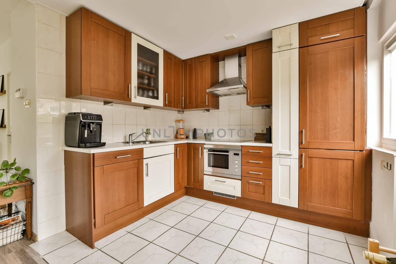 a kitchen with wood cabinets and white tiles on the floor in front of the oven, microwave and dishwasher