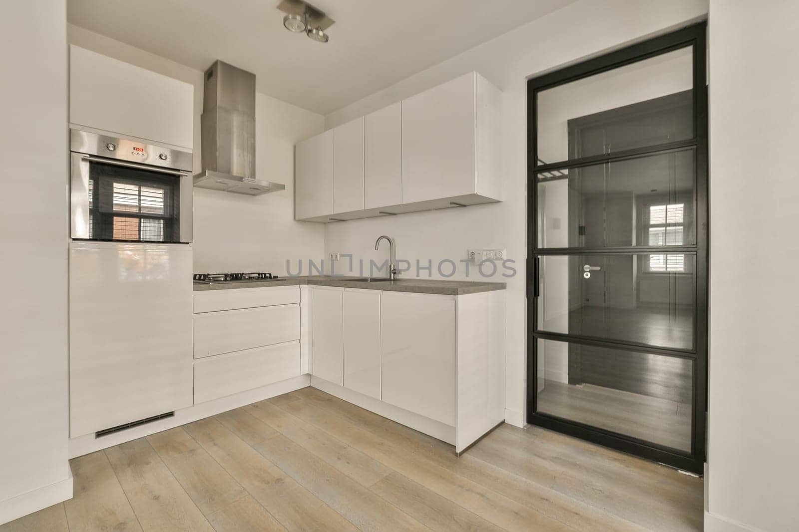 a kitchen with white cabinets and a glass door by casamedia
