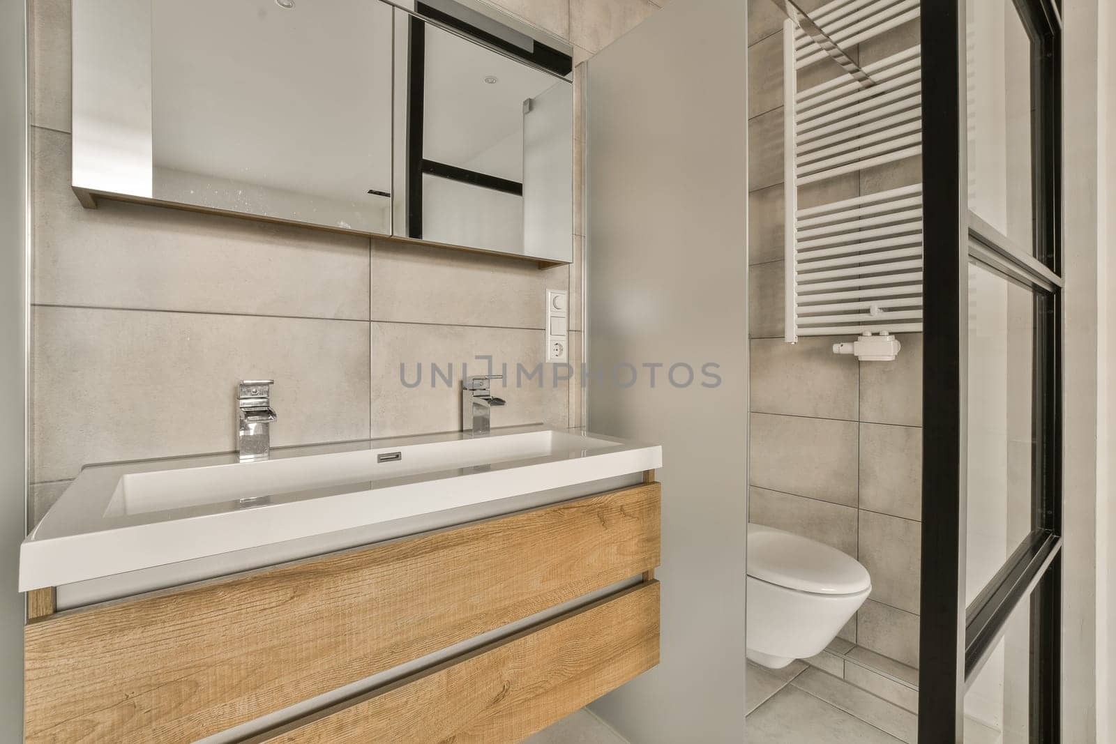 a modern bathroom with wood cabinets and white tiles on the walls, along with a toilet in the middle part of the room