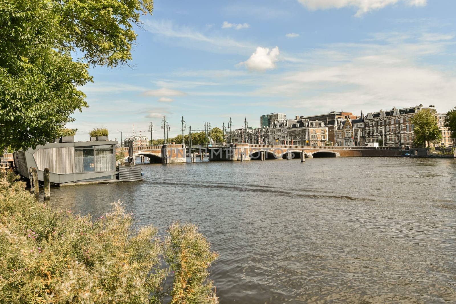 a view of a river with a bridge and buildings by casamedia