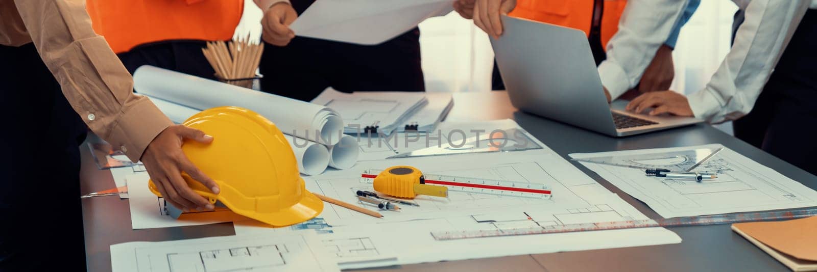 Engineer partner drawing and working on blueprint design together on office table for architectural building construction project. Architect drafting interior blueprint layout. Insight