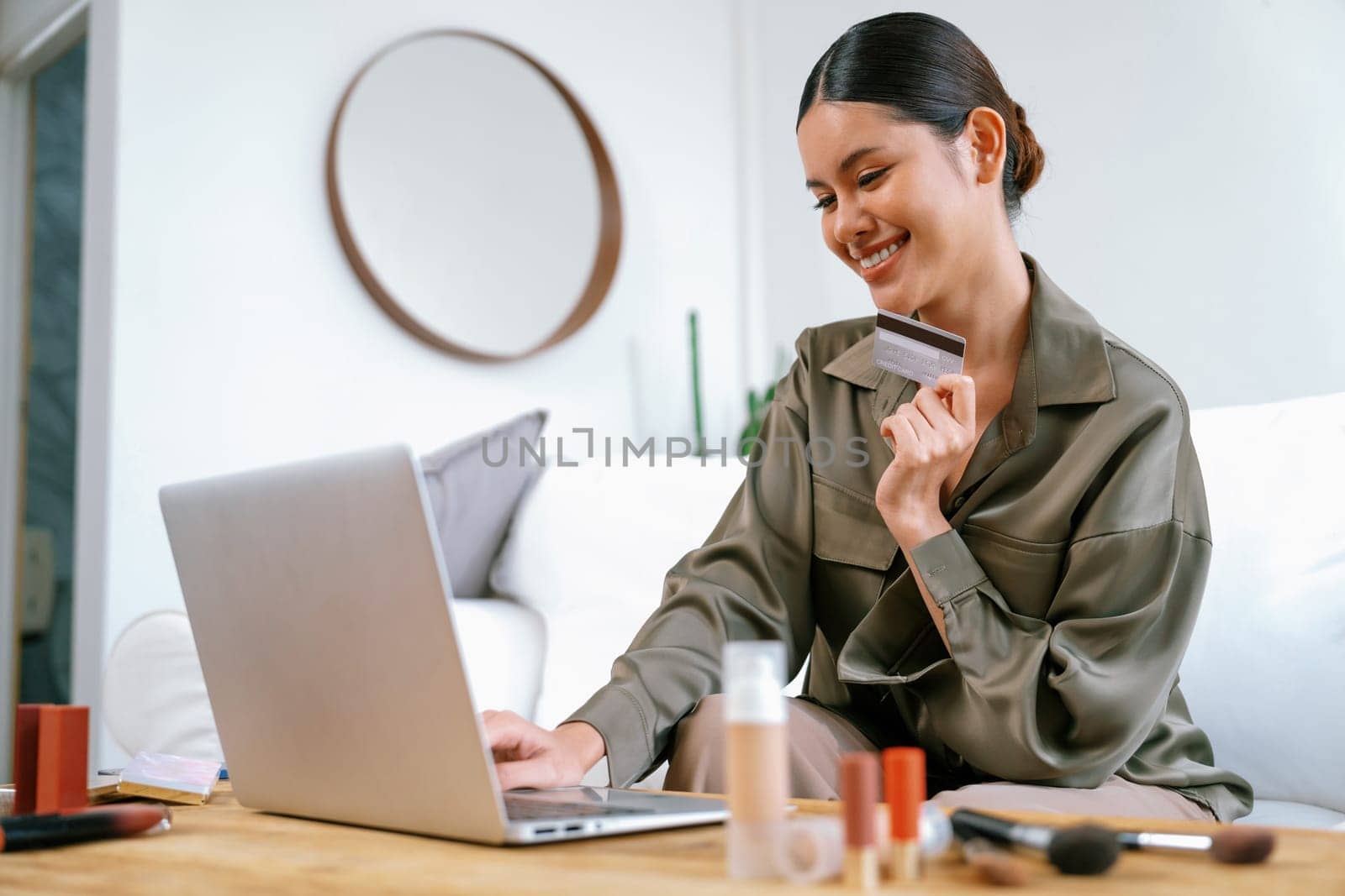 Young happy Asian woman buy product by online shopping at home while ordering items from the internet with credit card online payment protected by uttermost cyber security from online store platform