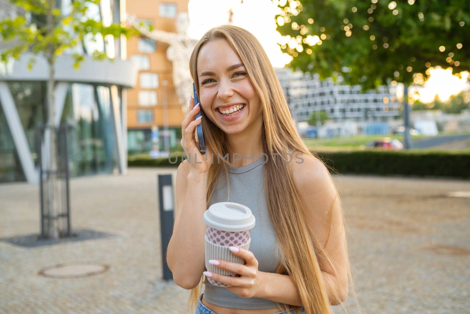Happy woman talking on phone and smiling at the camera.