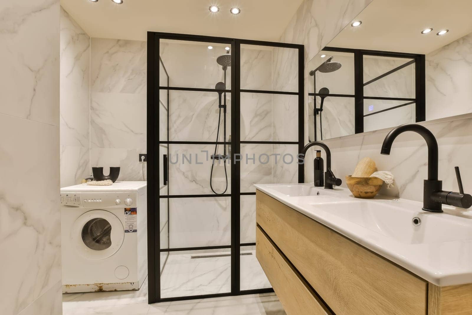 a modern bathroom with white marble walls and black framed mirrors on the wall, there is a washer in the corner