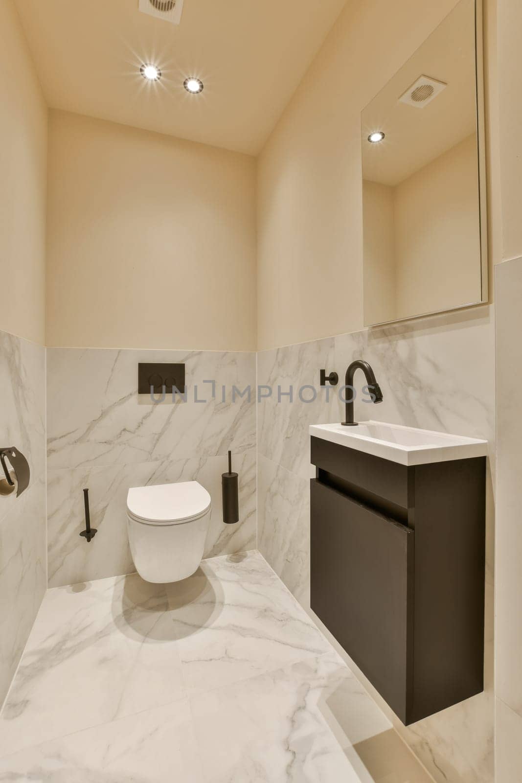 a modern bathroom with marble flooring and white walls, along with a black vanity in the room is illuminated by recessed lights