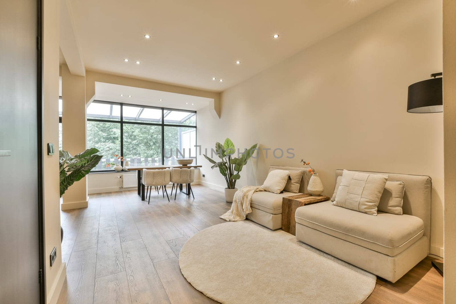 a living room with a couch, chair and coffee table on the floor in front of an open glass door