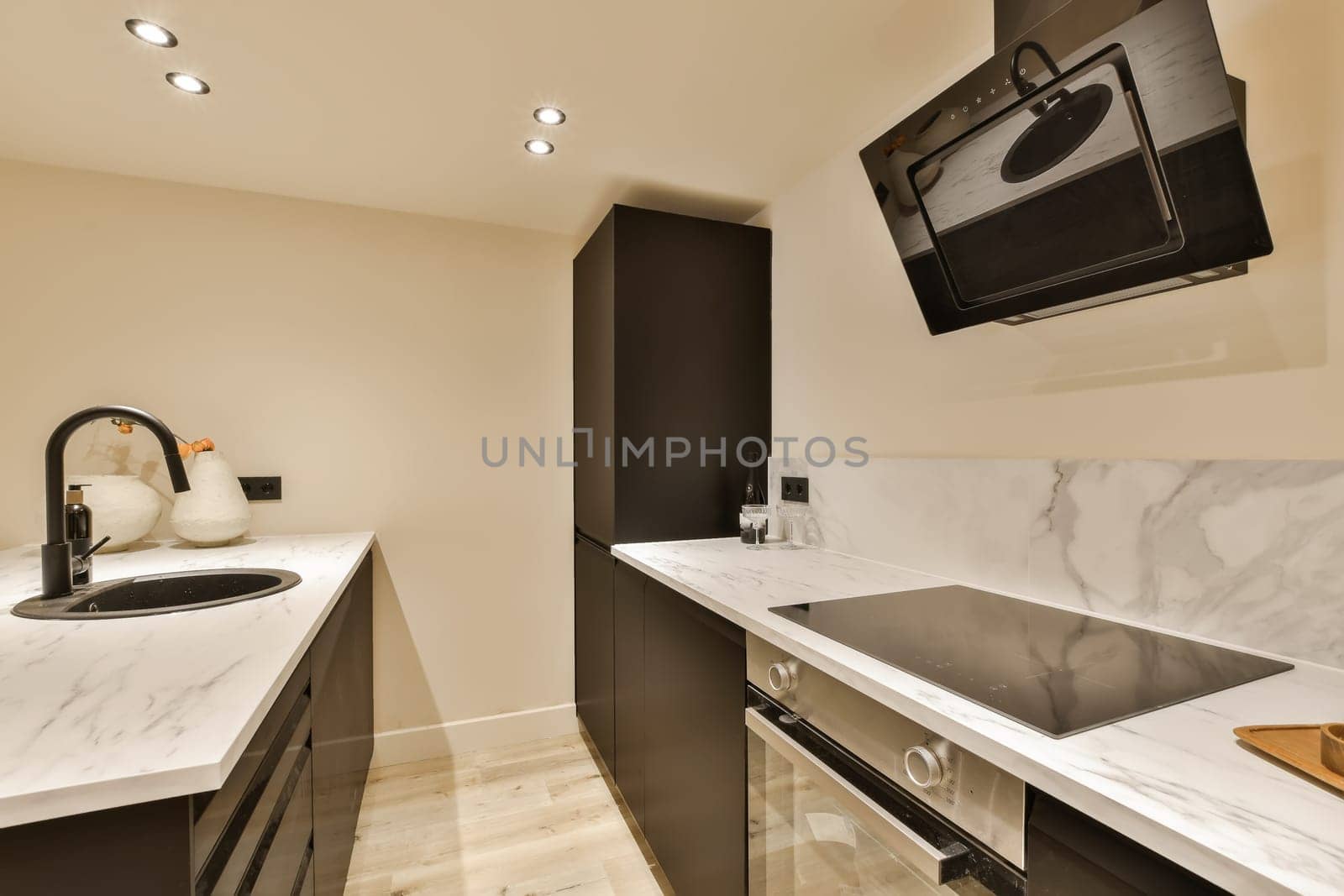 a modern kitchen with marble counter tops and black appliances on the wall mounted tv above the sink is also visible