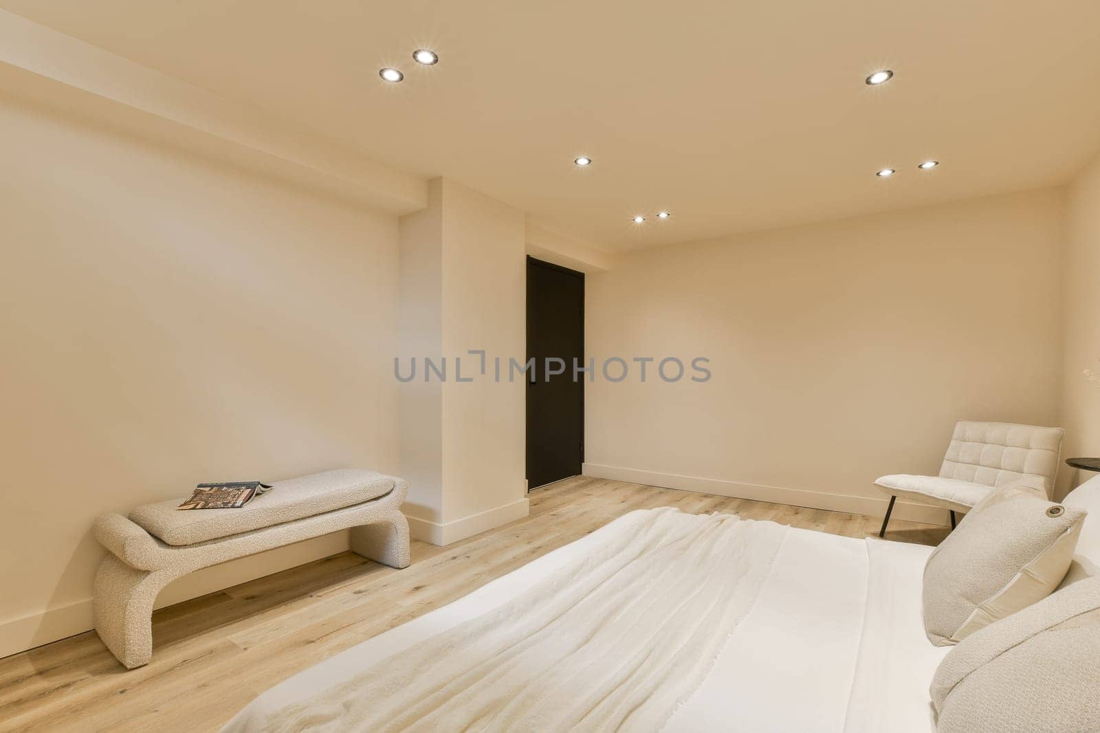 a bedroom with white walls and wood flooring in the middle, there is a bed on the right side