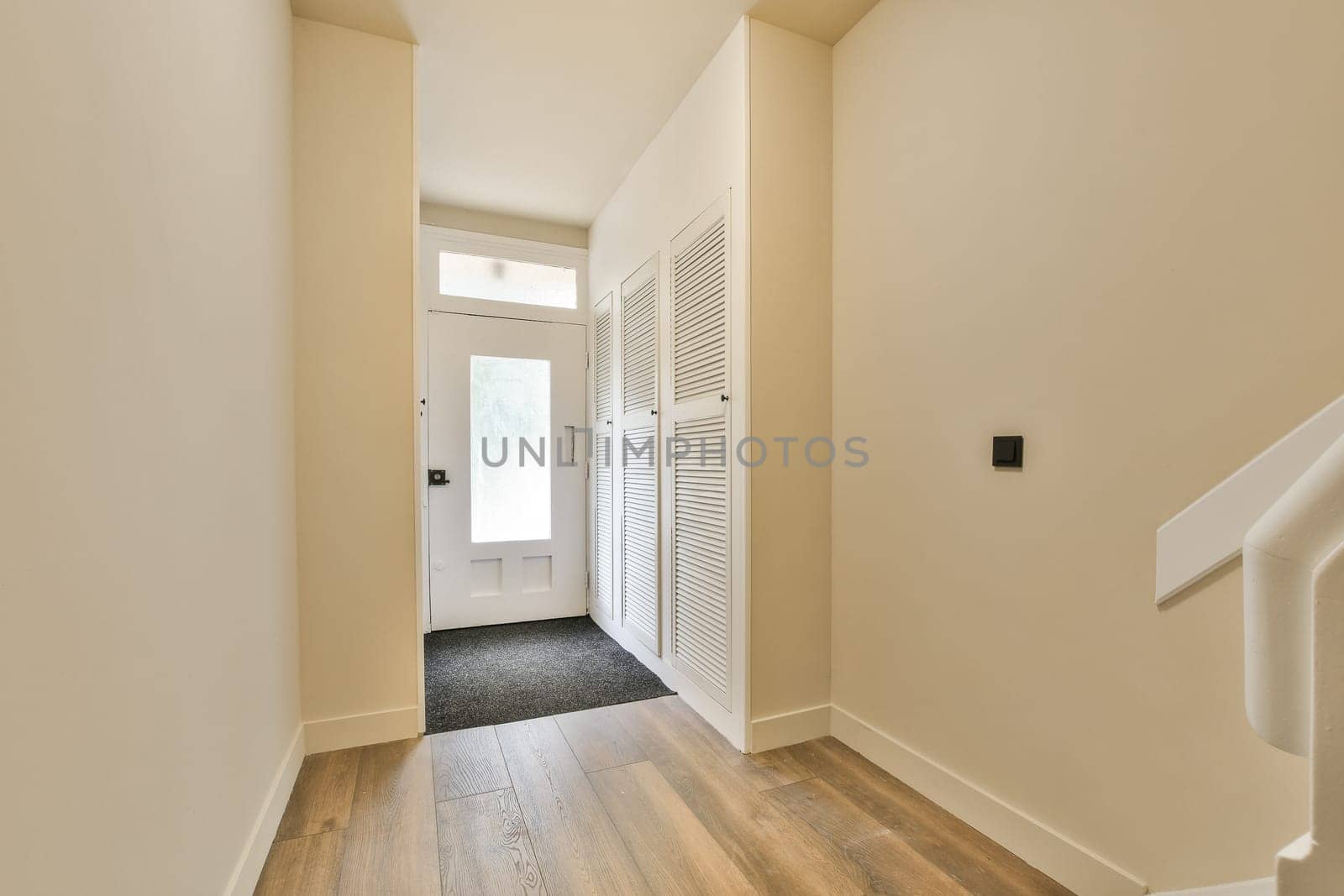 an empty room with wood flooring and white shutters on the wall behind it is a door that leads to another room