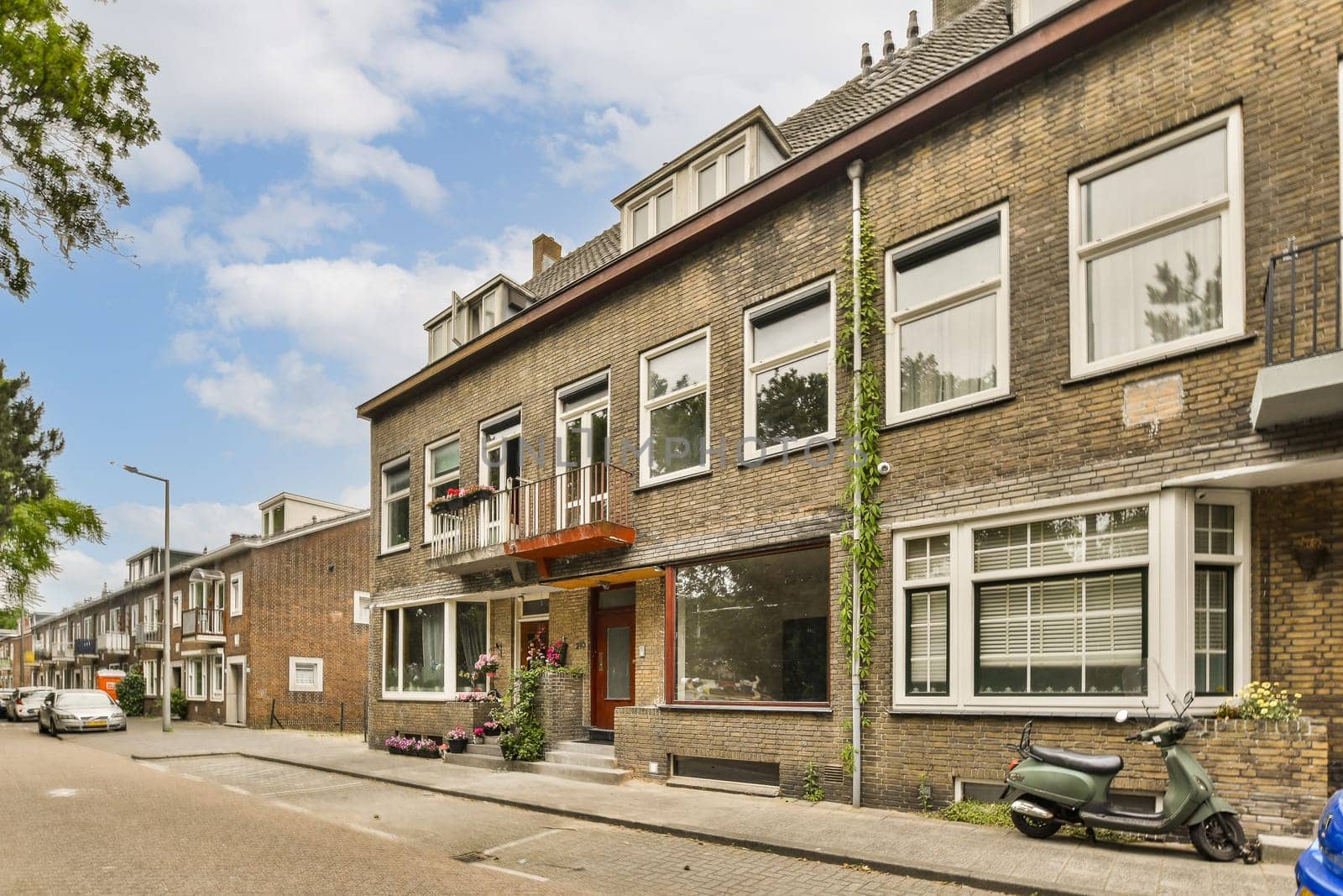 a city street with parked moped scoots on both sides and windows in the middle part of the street