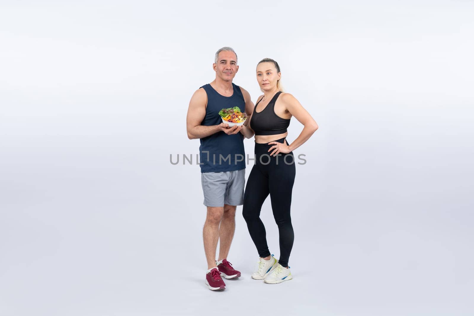 Happy smile senior man and woman portrait holding bowl of vegan fruit and vegetable on isolated background. Healthy senior couple with healthy vegetarian nutrition and body care lifestyle. Clout