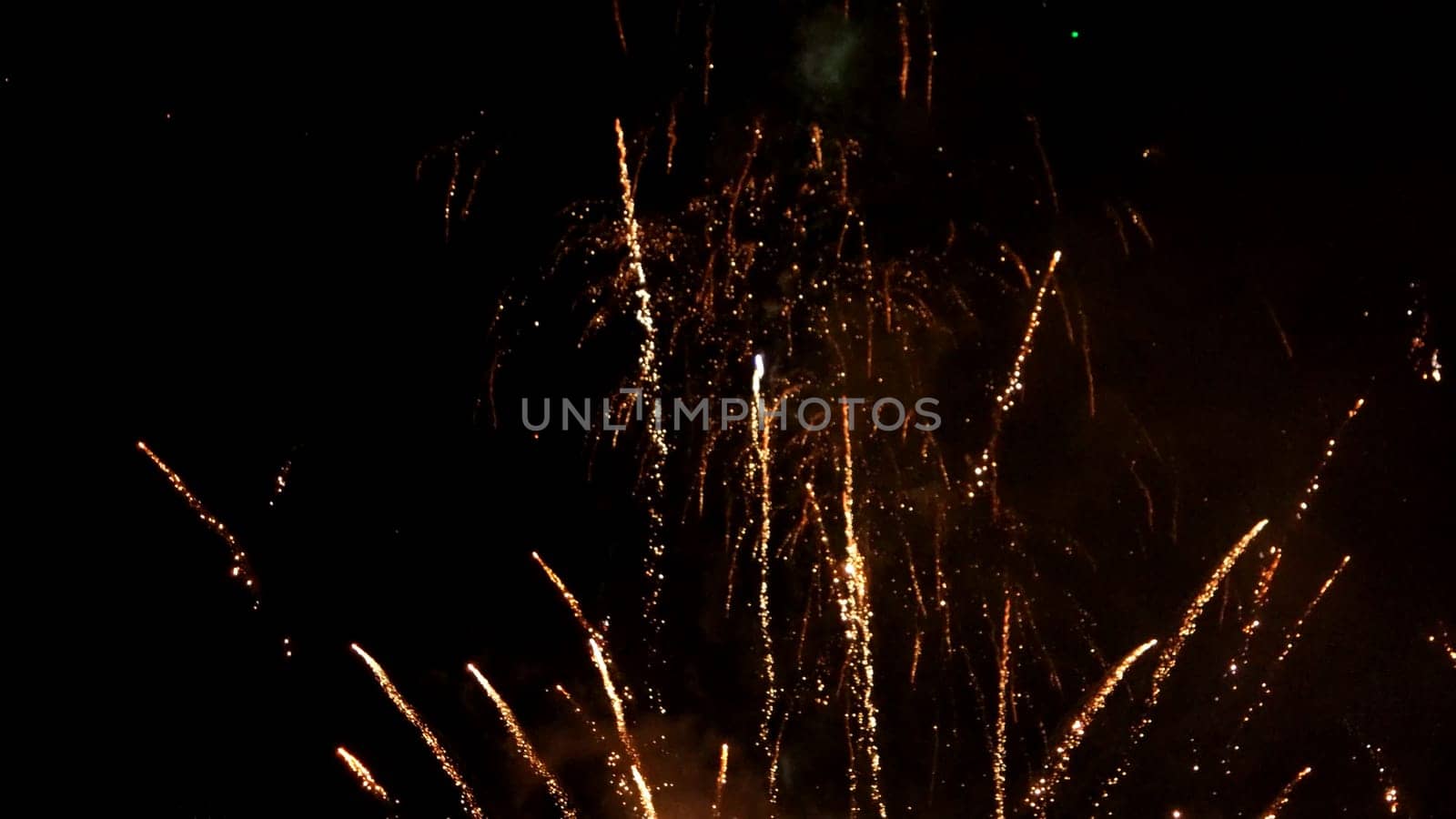 Multiple fireworks explosions on a dark night sky.