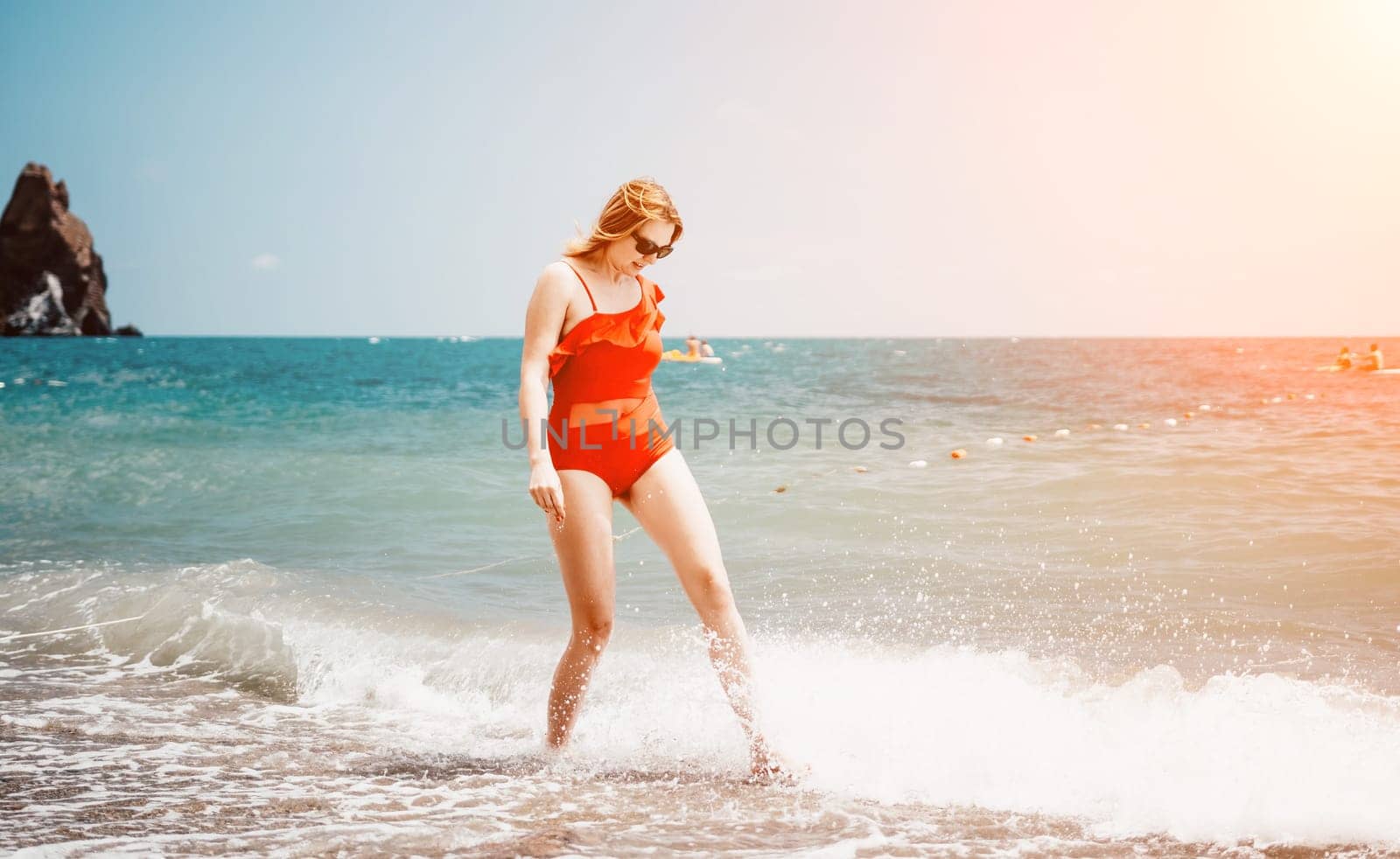 Pretty young blonde woman walking on the beach in summer, having fun, walks carefree on the seaside . Portrait beautiful young woman relax smile around beach sea ocean in holiday vacation travel trip.