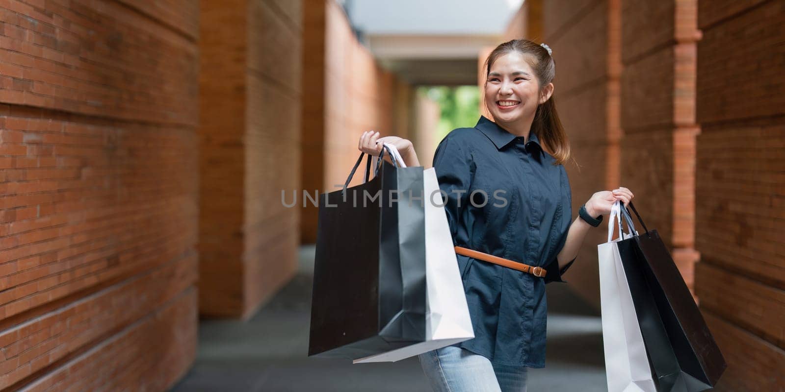 Young asian woman in shopping. Fashion woman in black with shopping bag walking around the city after shopping. Black friday.