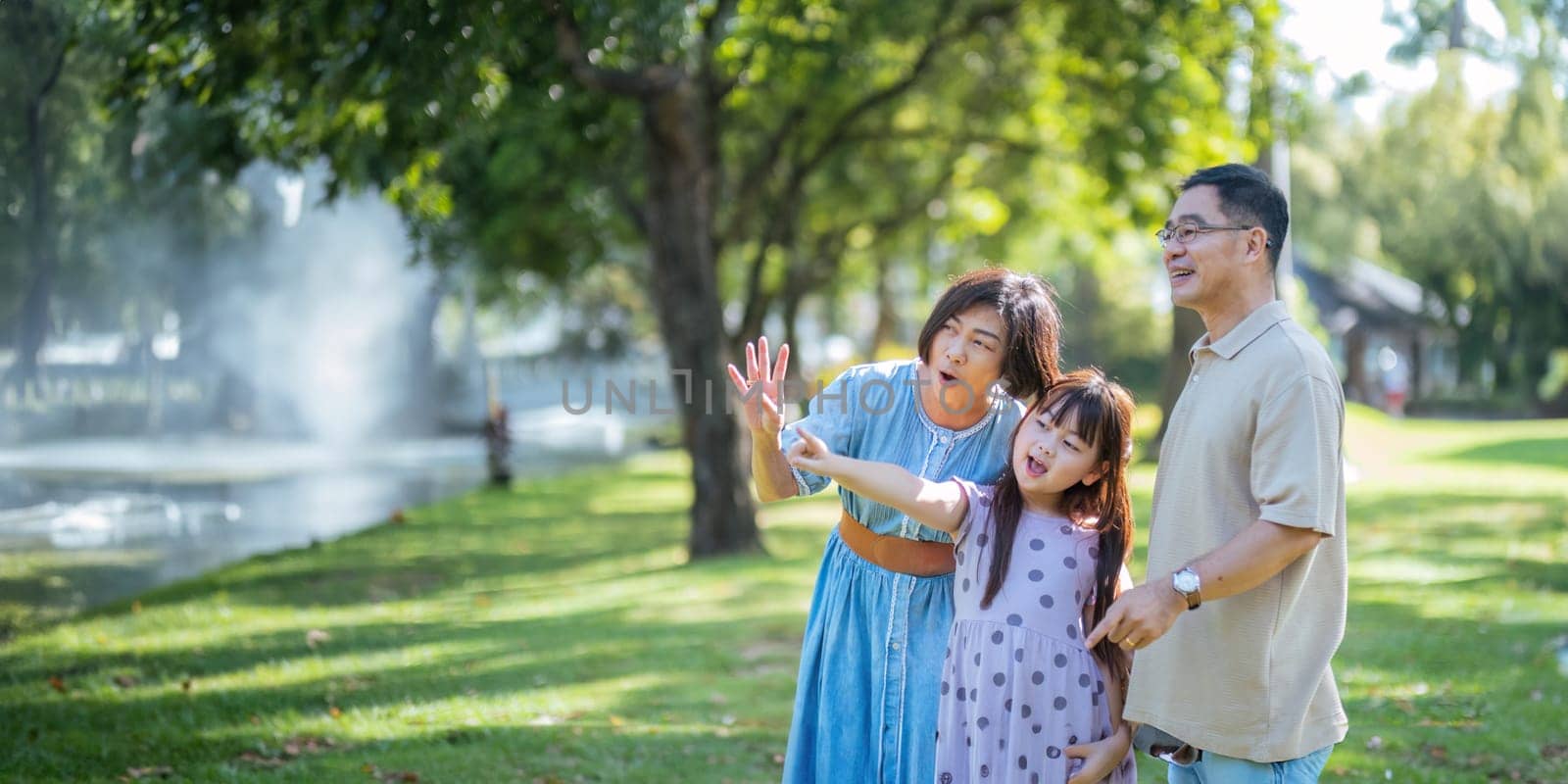 Grandparent playing togetherness with a granddaughter in the park in the morning. Family, love and grandchild bonding with grandfather and grandma in a park. concept child and senior by nateemee